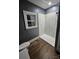 This bathroom has wood-look flooring, a new shower, and a window for natural light at 1703 Polk St, Monroe, NC 28110
