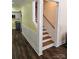 Inviting hallway featuring hardwood floors, white trim, and staircase access to the upper level, ensuring warmth at 1703 Polk St, Monroe, NC 28110