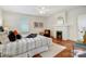 Bedroom featuring hardwood floors, ceiling fan, and painted brick fireplace at 1717 Thomas Ave, Charlotte, NC 28205
