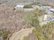 Aerial shot of wooded property with road access and commercial buildings nearby at 2018 Fox Creek Trl, Lincolnton, NC 28092