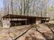 Open-sided barn or storage shed structure in a wooded area, ideal for equipment storage at 2018 Fox Creek Trl, Lincolnton, NC 28092