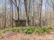 A weathered wood shed and metal shed sit amid a leafy, wooded property at 2018 Fox Creek Trl, Lincolnton, NC 28092