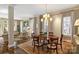 Bright dining room with an elegant chandelier, hardwood floors, and access to the living room at 2021 Nolen Park Ln, Charlotte, NC 28209