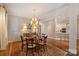 Dining room with dark hardwood floors, an elegant chandelier, and a view into the kitchen at 2021 Nolen Park Ln, Charlotte, NC 28209