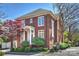 Charming two-story brick home with a manicured lawn, lush landscaping, and inviting front entrance with white columns at 2021 Nolen Park Ln, Charlotte, NC 28209