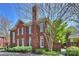 Brick home with lush landscaping, green bushes, mature trees, and manicured bushes around the home's perimeter at 2021 Nolen Park Ln, Charlotte, NC 28209