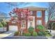 Attractive brick home featuring manicured landscaping, a red maple tree, and an attached two-car garage at 2021 Nolen Park Ln, Charlotte, NC 28209