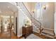 Elegant foyer featuring hardwood floors, a staircase with wrought iron railing, and a decorative chest at 2021 Nolen Park Ln, Charlotte, NC 28209