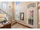 Inviting foyer with hardwood floors, staircase with carpet, and a decorative mirror with views of the outside at 2021 Nolen Park Ln, Charlotte, NC 28209