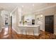 Bright kitchen features white cabinetry, hardwood floors, a breakfast bar with stools, and stainless steel appliances at 2021 Nolen Park Ln, Charlotte, NC 28209