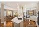 Open-concept kitchen features an island with barstool seating, white cabinets, hardwood floors, and stainless steel appliances at 2021 Nolen Park Ln, Charlotte, NC 28209