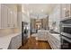 Kitchen featuring white cabinets, stainless steel appliances, a cozy breakfast nook, and hardwood flooring at 2021 Nolen Park Ln, Charlotte, NC 28209