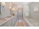 Bright bathroom features double sinks, soaking tub, and walk-in shower at 2021 Nolen Park Ln, Charlotte, NC 28209