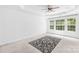 Bright, carpeted bedroom with tray ceilings, fan, three windows, and natural light at 20827 Brinkley St, Cornelius, NC 28031