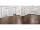 Spacious living room featuring hardwood floors, elegant trim, and abundant natural light from large windows at 20827 Brinkley St, Cornelius, NC 28031