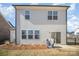 A view of the home's backyard with sliding glass doors opening onto a small concrete patio at 2105 Moss Bluff Dr, Mint Hill, NC 28227