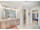 Bright bathroom featuring a double vanity with a decorative rug and entrances to the walk-in closet and toilet at 2105 Moss Bluff Dr, Mint Hill, NC 28227