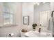 Cozy half bath with a decorative mirror, pedestal sink, and a view of the neighborhood at 2105 Moss Bluff Dr, Mint Hill, NC 28227