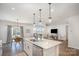 Open-concept kitchen features an island with a sink, pendant lighting, and a view into the living area at 2105 Moss Bluff Dr, Mint Hill, NC 28227