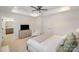 Bright main bedroom showcasing a ceiling fan, tray ceiling, and adjacent bath at 2105 Moss Bluff Dr, Mint Hill, NC 28227