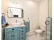 Stylish bathroom features a vintage blue vanity, marble countertops, and a modern shower with glass door at 2132 Rolston Dr, Charlotte, NC 28207