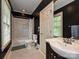 Elegant bathroom features black and white design with a tiled shower, pedestal sink, and natural light at 2132 Rolston Dr, Charlotte, NC 28207