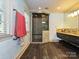 Bright bathroom featuring a glass shower, stone floor and vanity with dark cabinets and marble countertops at 2132 Rolston Dr, Charlotte, NC 28207