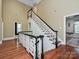 Staircase featuring hardwood floors, black handrails, and neutral wall color at 2132 Rolston Dr, Charlotte, NC 28207