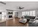 Open living room with hardwood floors, white brick fireplace, shelving, and comfortable gray sectional at 22 Honeysuckle Ln, Clover, SC 29710