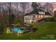 Aerial view of the backyard with pool, patio, tiered landscaping, and screened porch at 221 Colony Dr, Mooresville, NC 28115