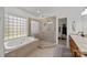 Bright bathroom features a soaking tub under a glass block window and a seamless glass shower at 221 Colony Dr, Mooresville, NC 28115