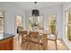 Sunlit dining area featuring a modern light fixture, views of the landscape, and a wooden table at 221 Colony Dr, Mooresville, NC 28115