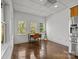 Bright home office features three windows, stained concrete floors and a desk with a comfortable chair at 221 Colony Dr, Mooresville, NC 28115
