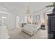 Bright main bedroom with a four-poster bed, neutral tones, and tray ceilings at 221 Colony Dr, Mooresville, NC 28115