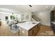 The kitchen island with quartz countertop provides seating and overlooks the open-concept living and dining areas at 3012 Yada Ln, Charlotte, NC 28208
