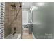 Bathroom with tiled shower and tub, modern vanity and fixtures, and a large window at 306 7Th Sw St, Hickory, NC 28602