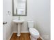 Contemporary half-bathroom with a pedestal sink, modern fixtures, and hardwood floors creating a stylish space for guests at 3711 Cole Mill Rd, Charlotte, NC 28270
