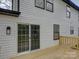 Exterior view of sliding glass doors to backyard wooden deck and white siding at 4427 Gaynelle Dr, Charlotte, NC 28215