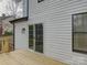 Exterior view of sliding glass doors to backyard wooden deck and white siding at 4427 Gaynelle Dr, Charlotte, NC 28215
