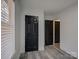 Bedroom closet with black doors and gray wood-look laminate flooring at 4427 Gaynelle Dr, Charlotte, NC 28215