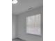 Bright bedroom features light gray flooring, a window with blinds, and white walls at 4427 Gaynelle Dr, Charlotte, NC 28215