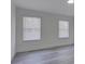 Vacant bedroom boasts gray flooring and two bright windows with blinds at 4427 Gaynelle Dr, Charlotte, NC 28215
