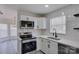 Modern kitchen featuring white subway tile backsplash, stainless steel appliances, and sleek cabinetry at 4427 Gaynelle Dr, Charlotte, NC 28215