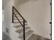 Clean and modern stairway with gray wood treads and dark metal railings at 4427 Gaynelle Dr, Charlotte, NC 28215