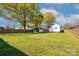 Spacious backyard featuring green grass, mature trees, storage shed, and a wooden perimeter fence at 48 Mandalay Sw Pl, Concord, NC 28027