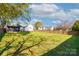 Large backyard with lush grass, mature trees, and a secure wooden fence at 48 Mandalay Sw Pl, Concord, NC 28027