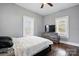 Comfortable bedroom with neutral paint, hardwood floors, modern dresser and television at 48 Mandalay Sw Pl, Concord, NC 28027