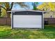 Detached garage with a white garage door; the garage is surrounded by a lush green yard and a wooden fence at 48 Mandalay Sw Pl, Concord, NC 28027