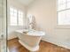 Bright bathroom featuring a freestanding tub with tray and wood-look flooring at 4912 Kenbury Ct, Fort Mill, SC 29708