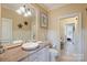 Traditional bathroom featuring a pedestal sink, wainscoting, decorative mirrors, and calming neutral tones at 525 Lake Lynn Rd, Concord, NC 28025